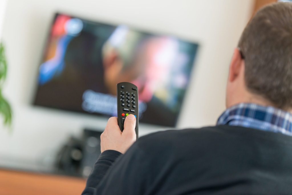 , 202403Man using remote for TV scaled 1